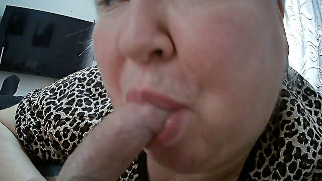 A fat woman makes a deep blowjob sucks balls and looks at a cumming dick