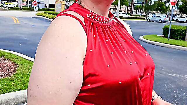 Beautiful woman walking outdoors in public parking lot showing off for strangers
